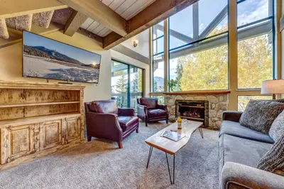 a living room with a couch and chairs and a fireplace at Greystone Lodge 318 Ski-in Out in Whistler
