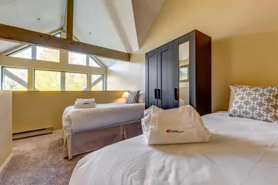 a bedroom with two beds and a large window at Greystone Lodge 318 Ski-in Out in Whistler