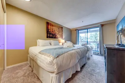 a bedroom with a large bed and a large window at Greystone Lodge 318 Ski-in Out in Whistler