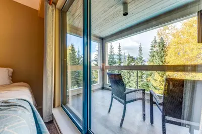 a bedroom with a bed and a window with a view at Greystone Lodge 318 Ski-in Out in Whistler