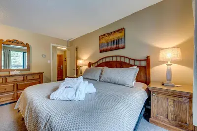 a bedroom with a bed with towels on it at Greystone Lodge 332 Ski-in Out in Whistler