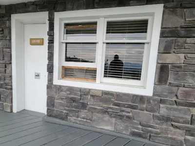 a person looking out the window of a building at Cross Suite - MistyRiver Lodge in Radium Hot Springs