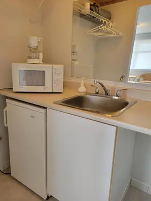 a kitchen with a sink and a microwave at Cross Suite - MistyRiver Lodge in Radium Hot Springs
