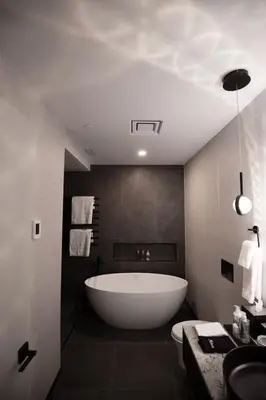 a large white tub in a bathroom with a sink at the reid hotel in Vanderhoof