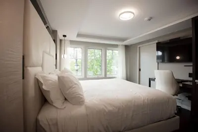 a bedroom with a white bed and a window at the reid hotel in Vanderhoof