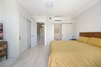 a white bedroom with a yellow bed in it at The Beach House at Saratoga #2 in Oyster Bay