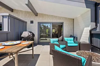 a patio with a wooden table and chairs at The Beach House at Saratoga #2 in Oyster Bay