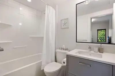 a white bathroom with a toilet and a sink at The Beach House at Saratoga #2 in Oyster Bay