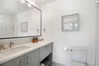 a bathroom with a sink and a toilet and a mirror at The Beach House at Saratoga #2 in Oyster Bay