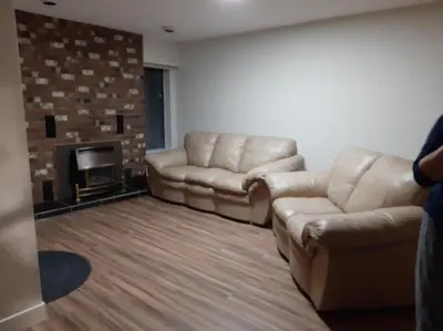 a living room with two leather couches and a fireplace at Farmestate in Vancouver