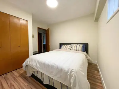 a bedroom with a bed and a wooden floor at Farmestate in Vancouver