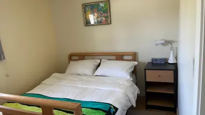 a small bedroom with a bed and a night stand at Big band house in Burnaby