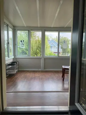 an empty living room with windows and a table at Big band house in Burnaby