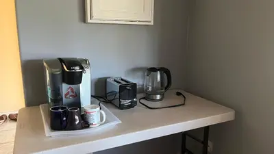 a counter with a coffee maker and coffee cups on it at Big band house in Burnaby