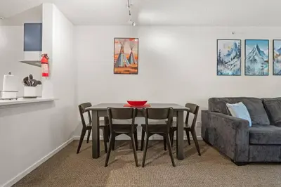 a dining room with a table and chairs and a couch at Reach Your Peak, Ski In, Ski Out, Pool, Hot Tub in Panorama