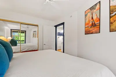 a white bedroom with a bed and a ceiling fan at Reach Your Peak, Ski In, Ski Out, Pool, Hot Tub in Panorama