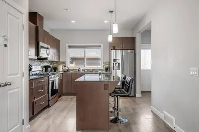 a kitchen with a island in the middle of it at Large House Near Calgary Airport with Central AC, Double Car Garage Parking, Upgrade Stay, Netflix, Sleeps 8 in Calgary