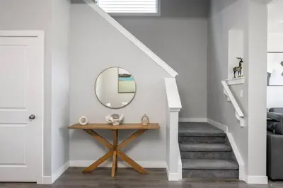a stairway with a mirror and a table at Large House Near Calgary Airport with Central AC, Double Car Garage Parking, Upgrade Stay, Netflix, Sleeps 8 in Calgary