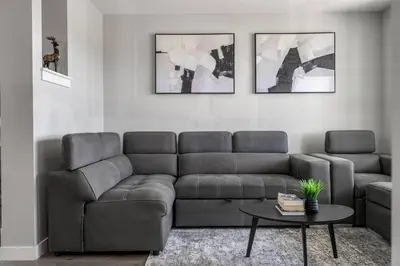 a living room with a couch and a table at Large House Near Calgary Airport with Central AC, Double Car Garage Parking, Upgrade Stay, Netflix, Sleeps 8 in Calgary