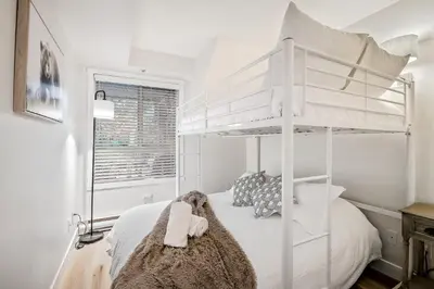a white bunk bed in a white room with a window at Whistler Village, Private Hot Tub, Free Parking in Whistler