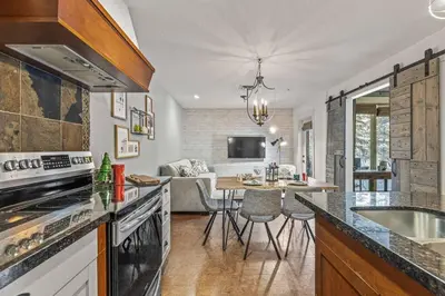 a kitchen with a counter and a table with chairs at L109 Canmore World Class Solara Resort - Hot tub, Pool, Gym, AirCon, Free Parking & Netflix in Canmore