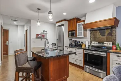 a kitchen with a sink and a stove top oven at L109 Canmore World Class Solara Resort - Hot tub, Pool, Gym, AirCon, Free Parking & Netflix in Canmore
