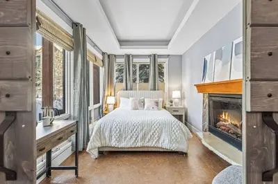 a bedroom with a bed and a fireplace at L109 Canmore World Class Solara Resort - Hot tub, Pool, Gym, AirCon, Free Parking & Netflix in Canmore