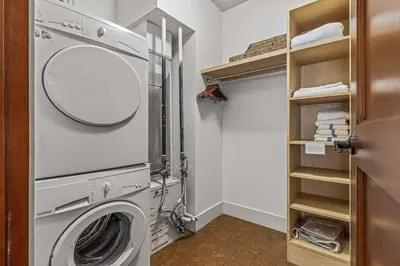 a laundry room with a washing machine and a mirror at L109 Canmore World Class Solara Resort - Hot tub, Pool, Gym, AirCon, Free Parking & Netflix in Canmore