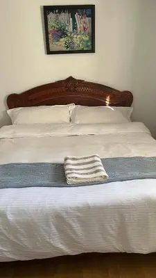 a bed with a wooden headboard with a towel on it at Big band home in Burnaby