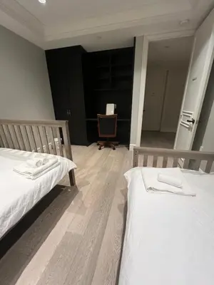 a room with two beds and a chair at Private Rooms in Vancouver West in Vancouver