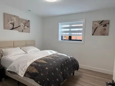 a white bedroom with a bed and a window at Calm & Cozy Private Suite in Surrey