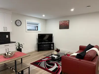 a living room with a red couch and a tv at Calm & Cozy Private Suite in Surrey