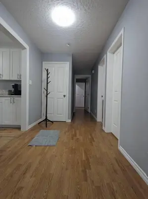 an empty living room with wooden floors and white walls at Charming 3 Bedroom Suite in Victoria