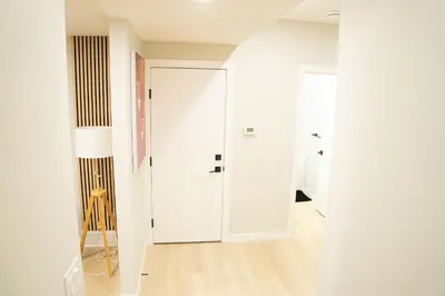 a hallway with white walls and a white door at The Old Trafford - Stylish 2 bed suite in Calgary