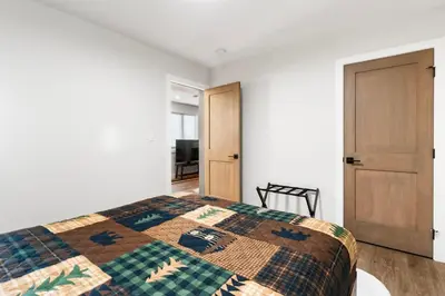 a bedroom with a bed with a quilt on it at Luxe Retreat by Canadian Rockies Vacation Rentals in Canmore