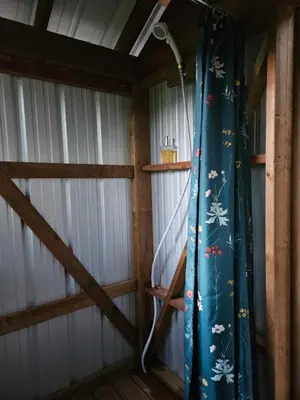 a room with a blue curtain in a barn at Zest Campers Ltd in Golden