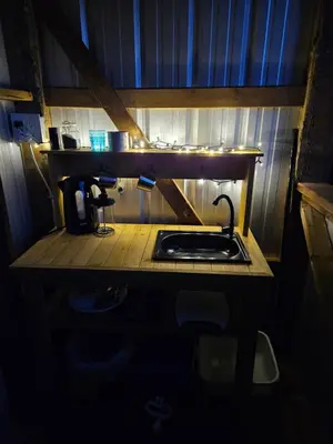 a kitchen counter with a sink in a dark room at Zest Campers Ltd in Golden