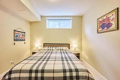 a bedroom with a bed with a plaid blanket at sweet home in Calgary