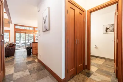 a hallway with wooden doors and tile flooring at Montebello 4877 by Outpost Whistler in Whistler
