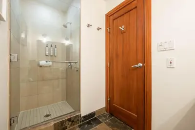 a bathroom with a shower and a wooden door at Montebello 4877 by Outpost Whistler in Whistler