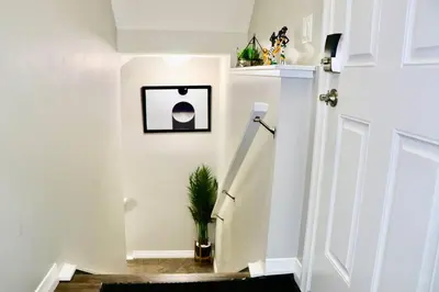 a hallway with a white door and a potted plant at Parkside Luxury Stay with Xbox Entertainment in Calgary