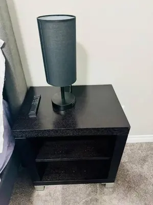 a lamp on a black table next to a bed at Parkside Luxury Stay with Xbox Entertainment in Calgary