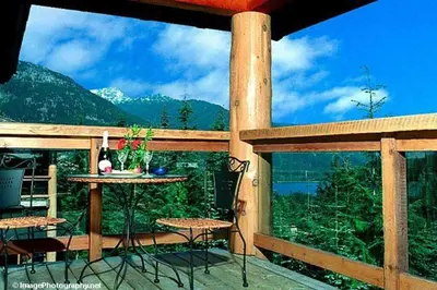 a patio with a table and chairs on a balcony at Whistler Highcamp in Whistler