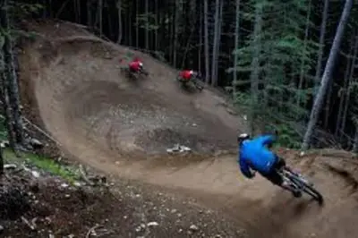 a group of people riding bikes on a dirt road at Whistler Highcamp in Whistler