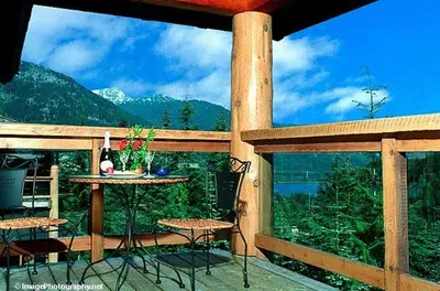 a patio with a table and chairs on a balcony at Whistler Highcamp in Whistler