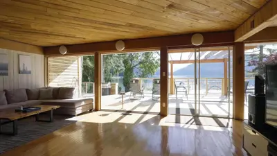 a living room with a couch and a table at Ozarks Luxurious Lakeside Villa at Harrison Lake in Harrison Hot Springs
