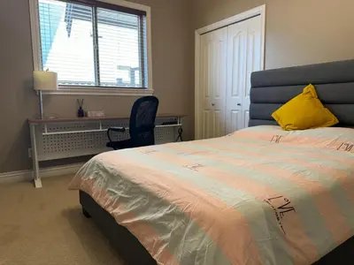 a bedroom with a bed with a yellow pillow and a chair at Zp Home in Richmond