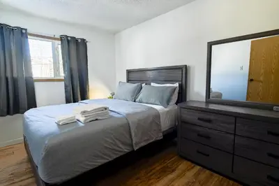 a bedroom with a bed with a dresser and a mirror at Cozy House in Haines Junction in Haines Junction