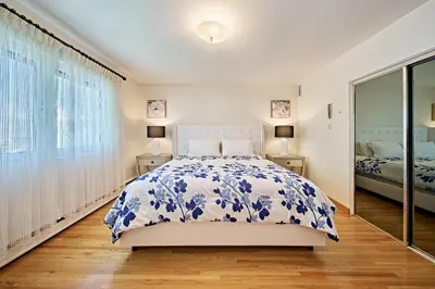 a white bedroom with a bed and a window at Chinook Executive Entire House in Calgary