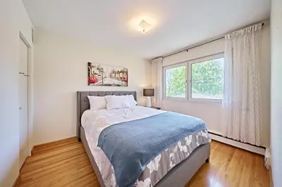 a bedroom with a large bed and a window at Chinook Executive Entire House in Calgary